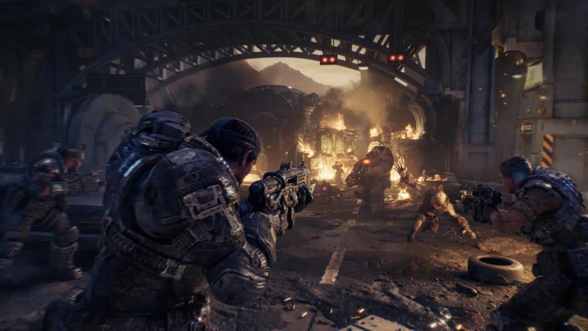 Des soldats en armure lourde affrontant des monstres dans un environnement urbain en ruines, tiré de Gears of War: E-Day.